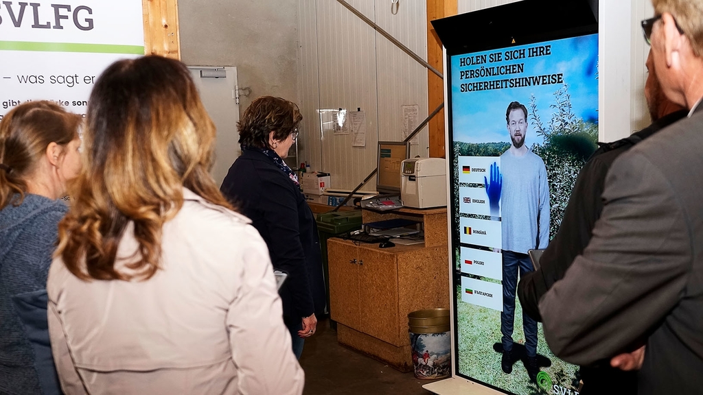 Vergrößerung des Bildes für Vier Personen stehen vor dem Terminal und testen die Funktionen aus.